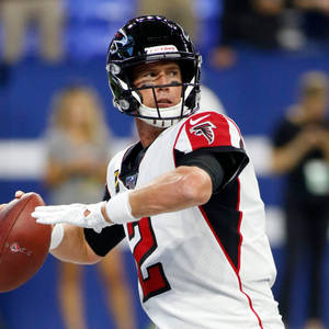 亞特蘭大獵鷹隊四分衛在夜間比賽中擲出橄欖球。 — NFL 美式足球 壁紙