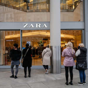 購物者晚上在 Zara 服裝店外排隊。 — Zara 壁紙