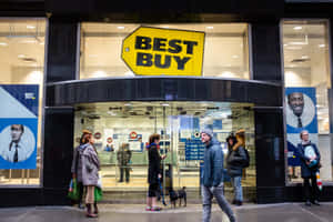 Best Buy商店外的人們，有玻璃門和黃色標誌 — 最佳購買 壁紙