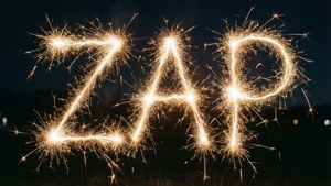 仙女棒在黑暗夜空中拼出ZAP，背景有模糊燈光。 — 電力 壁紙