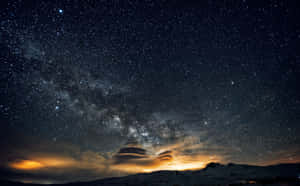 發光雲層下星空中的雪山 — 2880x1800 壁紙