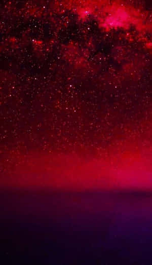在黑暗地平線上方，充滿恆星和宇宙塵埃的鮮豔紅色星系。 — 可愛的紅色 壁紙