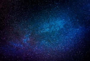 銀河系在深藍色和紫色中閃耀，襯托著繁星點點的夜空。 — 暮光 壁紙