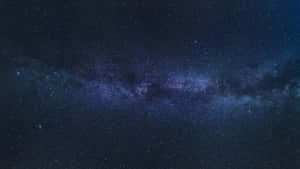 銀河系在黑暗的夜空中散發著紫色和藍色的星光。 — 星星 壁紙