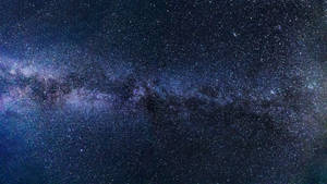 銀河系在漆黑的夜空中散發著紫色和藍色的星光。 — 星星 壁紙