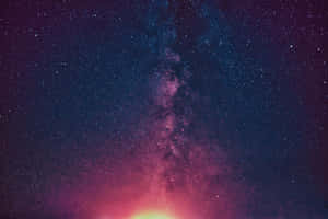 銀河系在繁星點點的夜空中散發著粉紅色和紫色的光芒。 — 淺粉色調 壁紙
