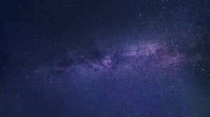 銀河系在漆黑的夜空中閃爍著紫色和藍色的星星。 — Pro Display XDR 壁紙