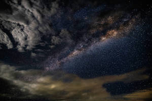 銀河系在繁星點點的夜空中透過烏雲閃耀。 — 夜晚 壁紙