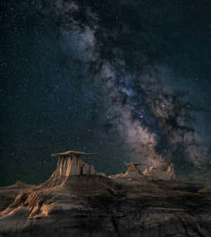 銀河系在繁星點點的夜空下照耀著沙漠岩層。 — 小米 Mix Fold 4 壁紙
