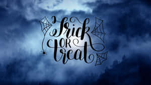 夜晚迷霧森林上方帶有蜘蛛網和蜘蛛的Trick or Treat文字。 — 秋季 壁紙