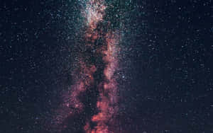 銀河系在繁星點點的夜空中散發粉紅和藍綠色星雲的光芒。 — 暮光 壁紙