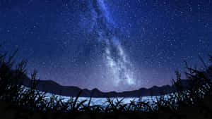夜晚，銀河系在湖面上，山脈和草叢剪影。 — 夜空 壁紙