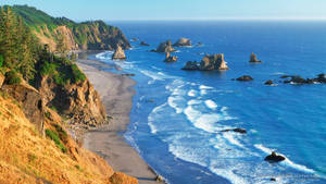 在晴朗的天空下，海岸峭壁與碧綠色的海浪和海蝕柱。 — 俄勒岡州 壁紙