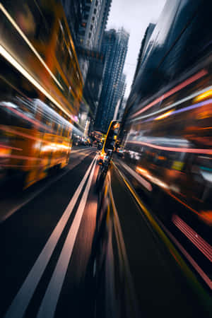 夜間城市街道，車輛燈光模糊地劃過高樓之間。 — Oppo Pad Mini 壁紙