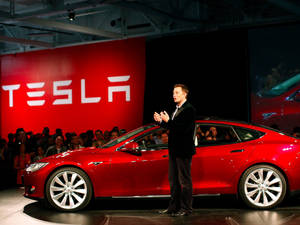 伊隆·馬斯克在產品發佈會上展示一輛紅色Tesla Model S。 — 伊隆·馬斯克 GIF 壁紙