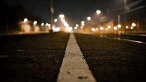 夜間道路，白色線條，模糊的街燈在前方。 — 街頭 壁紙