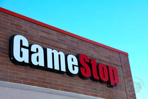 晴朗藍天下磚建築上的GameStop商店招牌 — 遊戲玩家標誌 壁紙