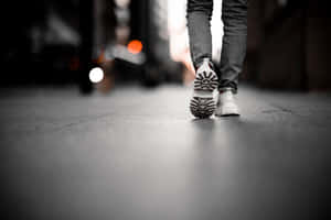 一個人在夜晚的城市街道上穿著白色運動鞋走開 — 鞋子 壁紙