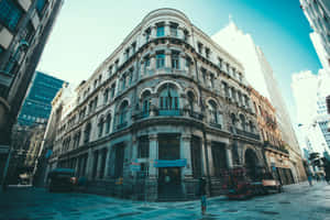 一座歷史悠久的石造建築，帶有拱形窗戶和陽台，位於城市街道上，有行人。 — 塔橋 壁紙