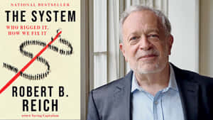 Robert B Reich身穿西裝，站在他的書籍封面旁，書名為The System。 — 書本 GIF 壁紙