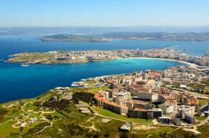 沿海城市，碧綠海灣與翠綠山丘，晴空萬里。 — 海景 壁紙