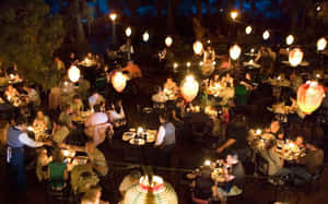 一個熱鬧的戶外餐廳夜景，有發光的燈籠和正在享用美食的食客。 — 美麗的藍色 壁紙