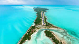 一條跑道橫跨狹長的熱帶島嶼，周圍環繞著碧綠的海水。 — 海灘 壁紙