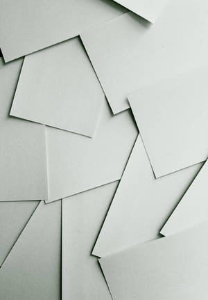 以簡約幾何排列堆疊的米白色紙張。 — 魯路修·蘭佩洛奇 壁紙