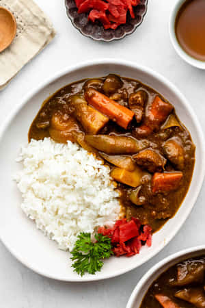 一個裝有咖哩飯和配料的碗，放在白色表面上。 — Huawei MatePad 11.5 S (2025) 壁紙