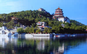 古老的中式寶塔和建築在陽光明媚的日子裡倒映在寧靜的湖面上。 — 自然 壁紙