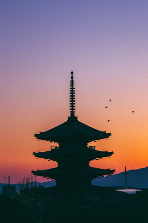 日落時分的寶塔剪影，鳥兒在橙色和紫色天空中飛翔 — 唐人街 壁紙