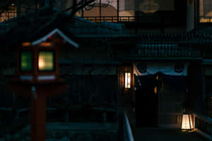 夜晚，一個發光的紅色燈籠矗立在傳統日本旅館前。 — 日式自然壁紙