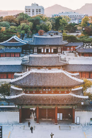 傳統韓國宮殿大門與秋葉和背景中的現代建築。 — 榮耀MagicPad 3 壁紙