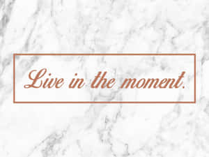 大理石背景，搭配玫瑰金文字，寫著 live in the moment。 — 語錄 壁紙