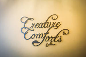 金屬牆藝，上面用優雅的草書寫著「Creature Comforts & Fierce」。 — 馴鹿 壁紙