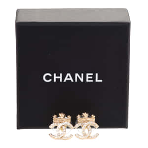 Chanel 金色水晶耳環展示在黑色品牌盒前。 — 香奈兒標誌 壁紙