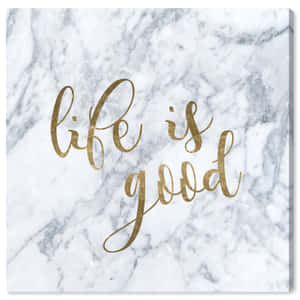 一塊大理石畫布，上面有金色字母寫著 life is good。 — 字體排印 壁紙