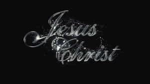 閃亮的銀色草書文字 Jesus Christ 帶有閃爍粒子在黑色背景上 — 耶穌被釘十字架 壁紙