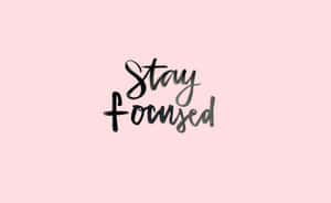 粉紅色背景上以黑色書法字體寫著「Stay Focused」的勵志文字。 — 焦點 壁紙