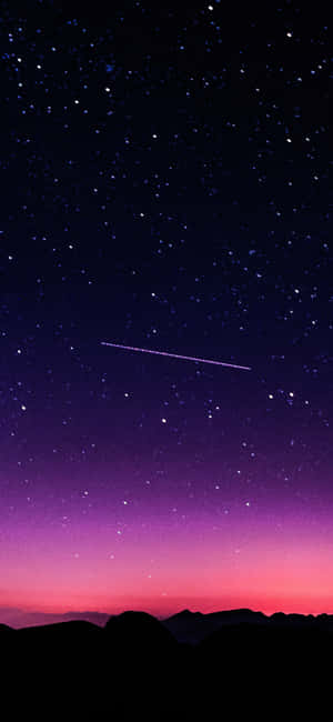 一顆流星劃過黑暗山脈剪影上方繁星點點的暮色天空。 — iPhone 18 Pro Max 壁紙