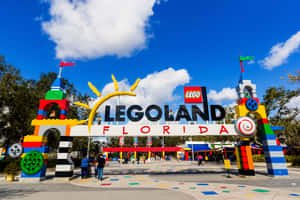 色彩繽紛的LEGO佛羅里達主題公園入口，微笑的太陽和遊客走過。 — 樂高 壁紙
