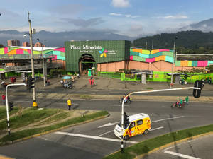 色彩繽紛的城市市場廣場，繁忙的十字路口有人群和車輛。
