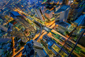 繁華現代城市的夜景鳥瞰圖，建築物和道路閃爍發光。