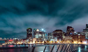 夜間城市景觀，燈火通明的建築物和水面倒影。 — 舊金山 壁紙