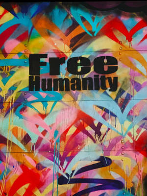 色彩繽紛的塗鴉藝術，金屬牆上寫有 Free Humanity 字樣。