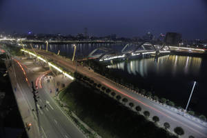 城市橋樑和道路的夜景，在河流上留下光跡。 — 孟加拉 壁紙