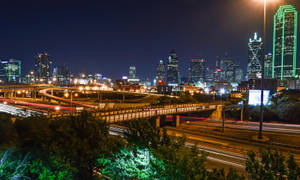 夜間城市，有燈火通明的摩天大樓和流動的車燈。 — 德州 壁紙