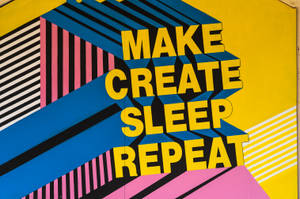 色彩繽紛的幾何壁畫上，粗體黃色文字寫著 make create sleep repeat。 — 普普藝術動圖 壁紙