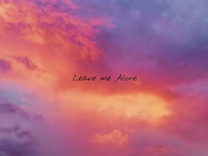 戲劇性的日落天空，帶有粉紅色、紫色和橙色的雲層和手寫文字 leave me alone。 — 夕陽天空 壁紙