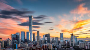 現代城市天際線在日落時分，色彩繽紛的雲彩和玻璃塔。 — 城市風景 壁紙
